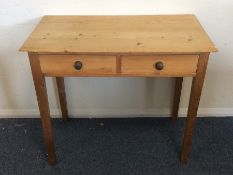 A pine two drawer side table on tapering supports.