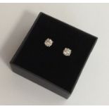 A pair of good diamond single stone ear studs in f