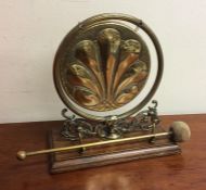 A stylish brass mounted dinner gong on wooden moun