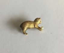 A novelty small gold brooch of a cat playing with
