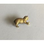 A novelty small gold brooch of a cat playing with