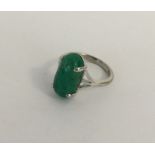 A cabochon emerald single stone ring in claw mount