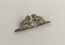 A novelty brooch depicting kittens playing with a