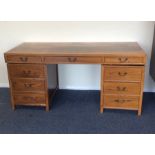 A large nine drawer twin pedestal desk with cast h