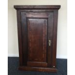 A Georgian oak corner cupboard with hinged front.