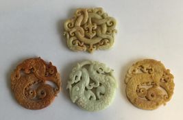 A group of four carved hard stone medallions. Est.