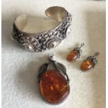 A Continental silver bangle together with an amber
