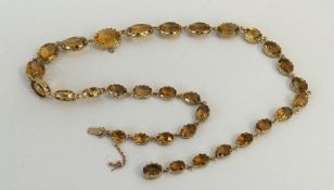 A heavy 9 carat tapering citrine necklace in claw