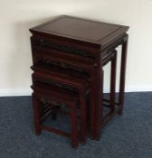 A nest of four hardwood tables of Oriental design.