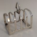 A silver five bar toast rack on bracket feet. Lond