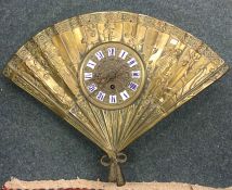 An unusual brass mounted wall clock in the form of