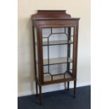 A mahogany glazed cabinet on tapering supports. Es