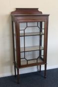 A mahogany glazed cabinet on tapering supports. Es