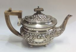 A good quality embossed silver teapot on ball feet