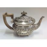 A good quality embossed silver teapot on ball feet