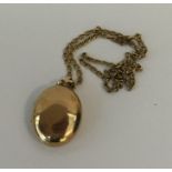 A 9 carat oval locket on fine link chain. Approx.