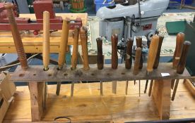 A quantity of woodworking chisels on stand.