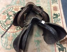 Two leather horse riding saddles.