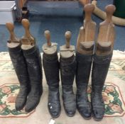 Three pairs of horse riding boots and trees.