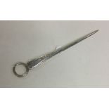 A tapering silver miniature meat skewer with ring