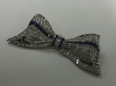 A large diamond brooch in the form of a bow with p