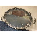 A heavy silver two handled tray with scroll decora
