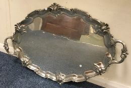 A heavy silver two handled tray with scroll decora