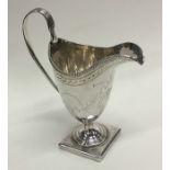 A Georgian bright cut silver cream jug decorated w