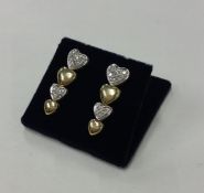 A pair of yellow gold and diamond heart shaped ear