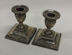 A pair of square based dwarf silver candlesticks w
