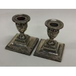 A pair of square based dwarf silver candlesticks w