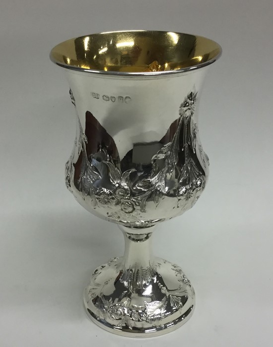 A chased Victorian silver goblet with gilt interio