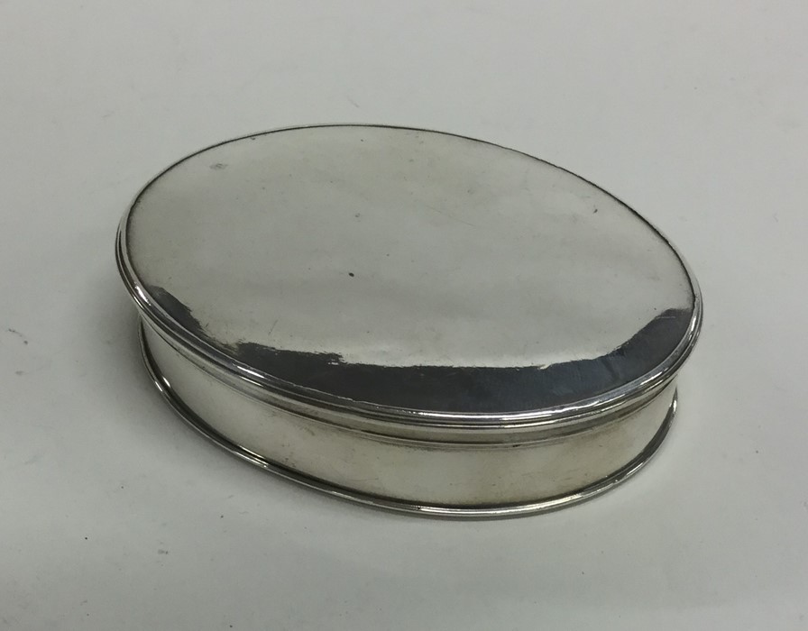 An 18th Century oval silver box with lift-off cove