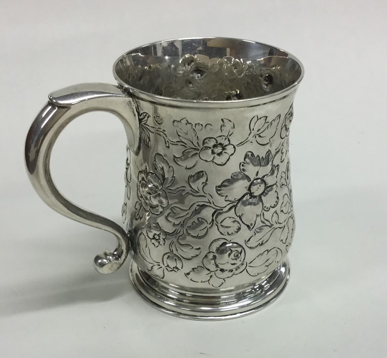 A Victorian silver embossed mug with floral decora