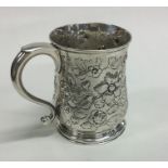A Victorian silver embossed mug with floral decora