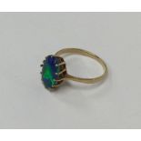 A large oval black opal single stone ring in claw