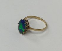 A large oval black opal single stone ring in claw