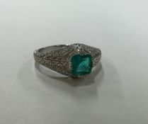 An Art Deco style emerald and diamond ring in plat