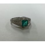 An Art Deco style emerald and diamond ring in plat