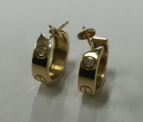 CARTIER: A good pair of diamond earrings of typica