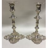 A pair of heavy cast silver candlesticks with cres
