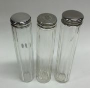 A group of three silver lidded dressing table jars