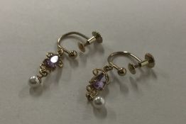 A pair of amethyst and pearl drop earrings set in