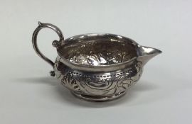 A small Russian silver cream jug with chased decor