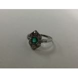 An Art Deco platinum set emerald and diamond ring