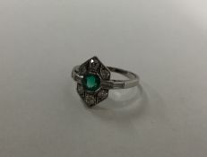 An Art Deco platinum set emerald and diamond ring