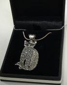 A large heavy silver pendant in the form of a cat