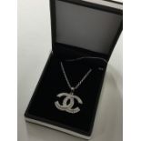 An unusual silver pendant decorated with a Chanel