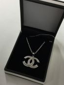 An unusual silver pendant decorated with a Chanel