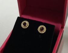 A pair of circular ruby and diamond cluster earrin